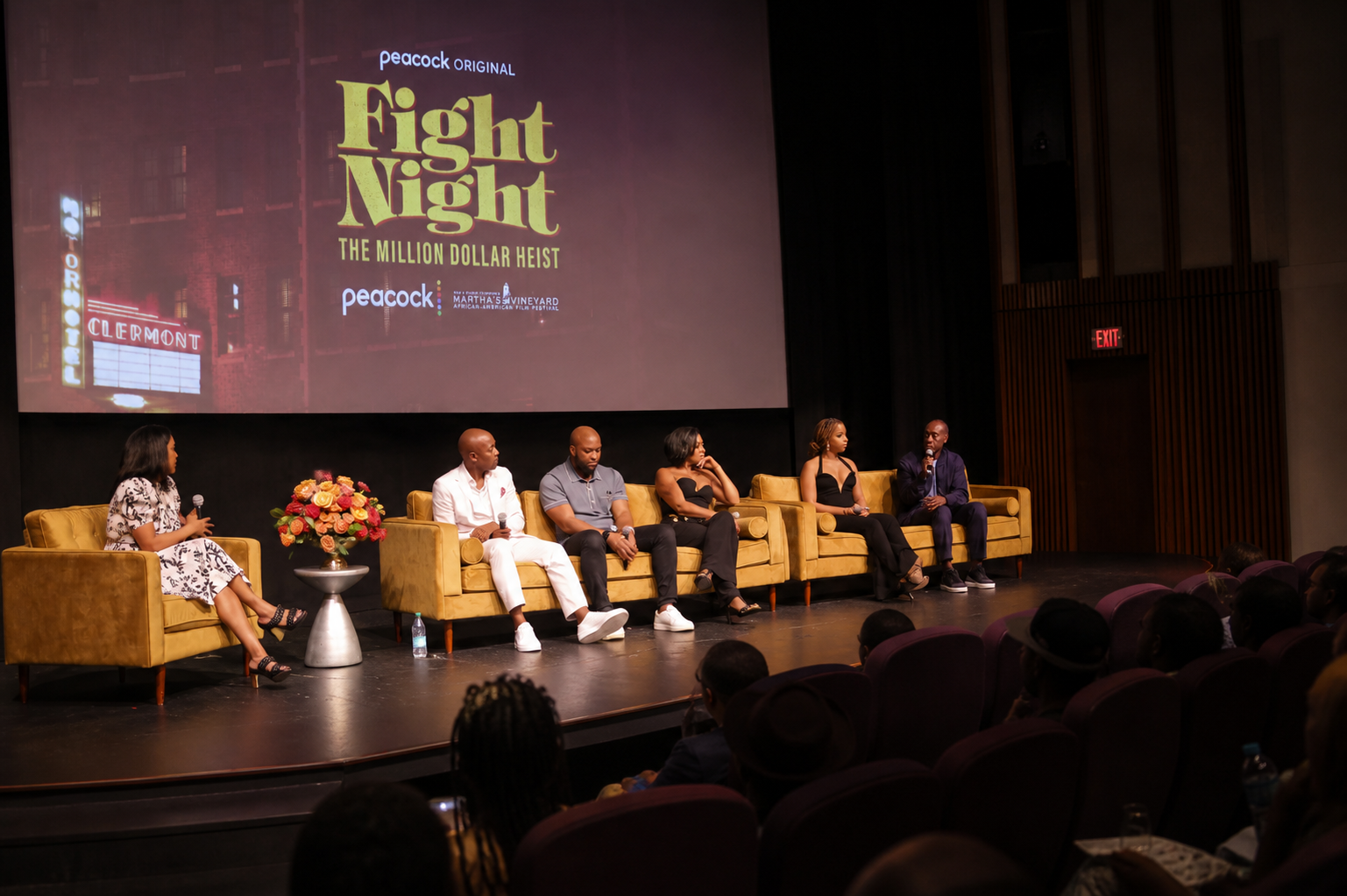 Panel discussion at the Martha's Vineyard African American Film Festival, with speakers on yellow velvet seating in front of a large screen showing festival and series branding.